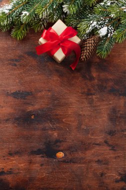 Noel hediye kutusu ve köknar ahşap arka plan üzerinde kar kapsamında şube ağaç. Üstten görünüm xmas zemin alan selam ile