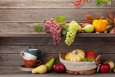 Sonbahar natürmort kabaklar, üzüm, elma, armut, kahve fincanı ile-oyun kağıdı ve renkli ahşap duvarın önünde bırakır. Senin metin için ile yer