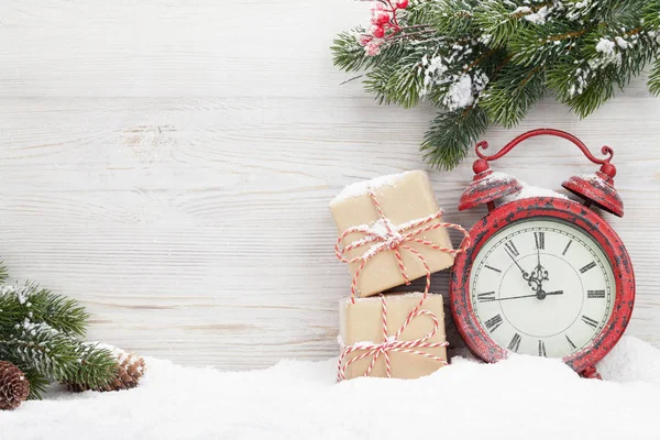 クリスマス ギフト ボックス 目覚まし時計 木製の壁の前に雪で覆われてモミの木の枝 コピー スペースを表示します — ストック写真