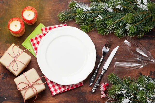 Ahşap arka plan üzerinde kar tarafından Noel tablo ayarını şampanya, hediye kutusu ve köknar ağacı dalı ile kaplı. Selam yeri olan üstten görünüm