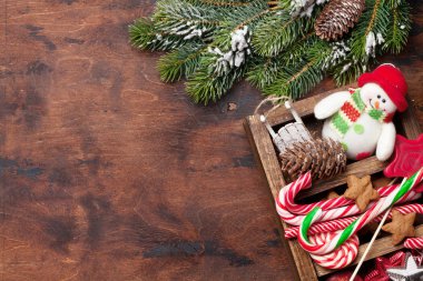 Noel dekor kutu ve köknar ahşap arka plan üzerinde kar kapsamında şube ağaç. Üstten görünüm xmas zemin alan selam ile