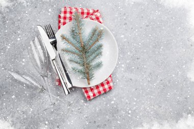 Noel tablo ayarı ile taş zemin üzerine tabak, çatal bıçak ve köknar ağacı dalı. Selam yeri olan üstten görünüm