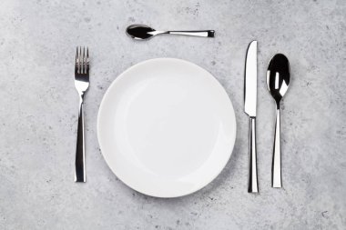 Tablo ayarı. Boş levha, bıçak, çatal ve kaşık. Üstten görünüm ve düz lay kopya alanı ile