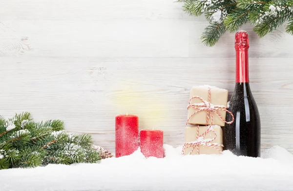 クリスマス ギフト ボックス シャンパン ボトルとクリスマス Fir ツリー ブランチ軽い木製の背景 — ストック写真