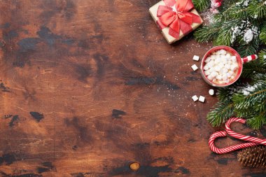 Noel hediye kutusu, şekerler, ahşap arka plan üzerinde kar kaplı hatmi ve köknar ağacı dalı ile sıcak çikolata. Üstten görünüm xmas zemin alan selam ile