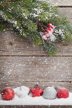Noel zemin ile kar ve dekor ahşap duvar önünde kapsadığı köknar ağacı dalı. Selam yeri olan Xmas arka plan