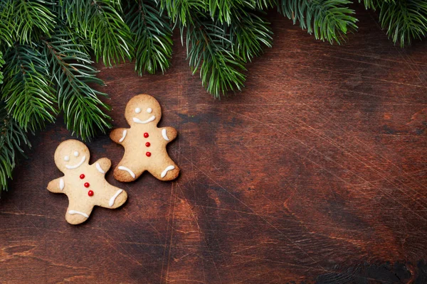 木製の背景にモミの木の枝をクリスマスのジンジャーブレッドのクッキー — ストック写真