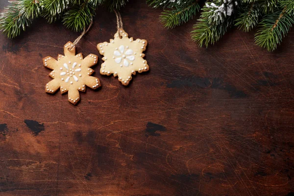 圣诞姜饼饼干和圣诞冷杉树枝在木背景 — 图库照片