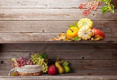 Kabak, elma, üzüm, armut ve ahşap duvar renkli yaprakları ile sonbahar natürmort