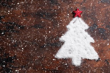 Noel köknar ağacı şeklinde kar ve ahşap zemin üzerinde kırmızı yıldız dekor