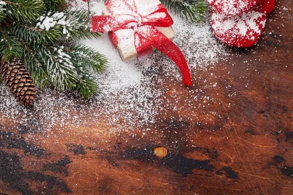 Weihnachtskarte Mit Geschenkschachtel Warmen Handschuhen Und Tannenzweigen Auf Holztisch — Stockfoto