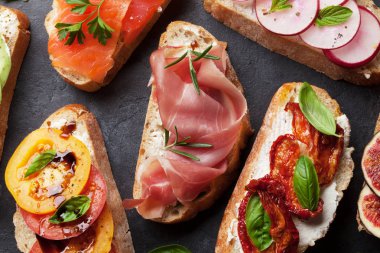 Geleneksel İspanyolca tapas bruschetta üstten görünüm karanlık taş zemin üzerine