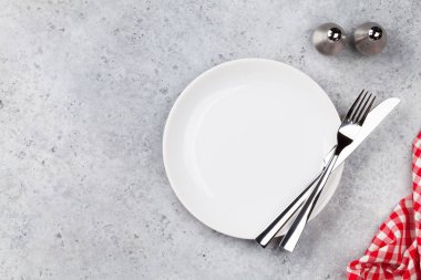 Tablo ayarı. Boş levha, bıçak, çatal, baharat ve peçete. Üstten görünüm ve düz lay kopya alanı ile