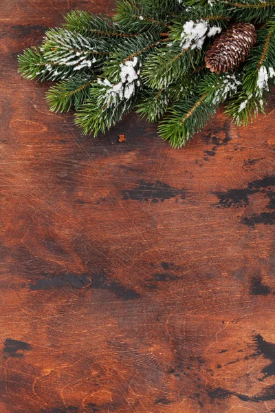 クリスマスのモミの木支店の木製の背景に雪で覆われています あなたの挨拶のためのスペースを上から見るクリスマス背景 — ストック写真