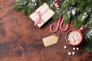 Noel hediye kutusu, şekerler, ahşap arka plan üzerinde kar kaplı hatmi ve köknar ağacı dalı ile sıcak çikolata. Üstten görünüm xmas zemin alan selam ile