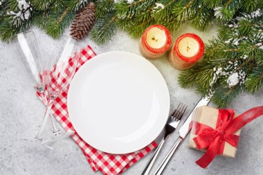 Taş zemin üzerine kar tarafından Noel tablo ayarını mumlar, şampanya, hediye kutusu ve köknar ağacı dalı ile kaplı. Selam yeri olan üstten görünüm