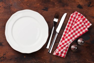 Tablo ayarı. Boş levha, bıçak, çatal, baharat ve peçete. Üstten görünüm ve düz lay kopya alanı ile