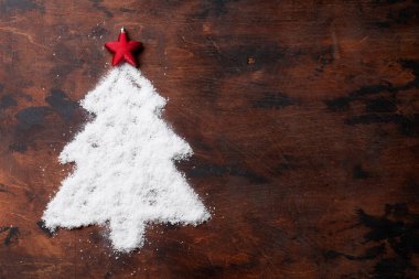 Noel köknar ağacı şeklinde kar ve ahşap zemin üzerinde kırmızı yıldız dekor