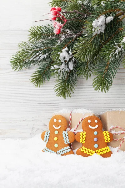 圣诞礼品盒 姜饼饼干和冷杉树枝覆盖在木墙前的雪 使用复制空间查看 — 图库照片