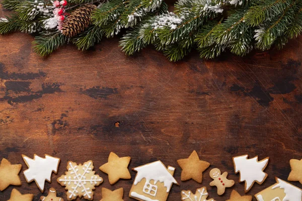 クリスマスのジンジャーブレッド クッキーと木製の背景にモミの木の枝 — ストック写真