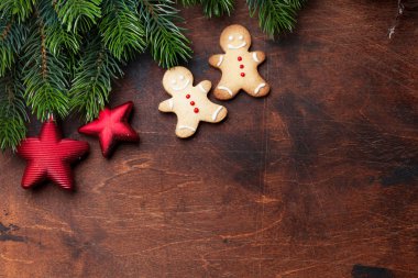 Noel gingerbread çerezleri, dekor ve xmas köknar ağacı dalı ahşap zemin üzerinde. Selam yeri olan üstten görünüm