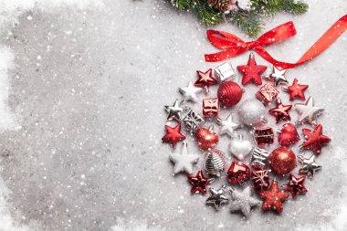 Gri beton zemin üzerinde kırmızı yay ve köknar ağacı dalları ile yıldız baubles ile Noel tebrik kartı