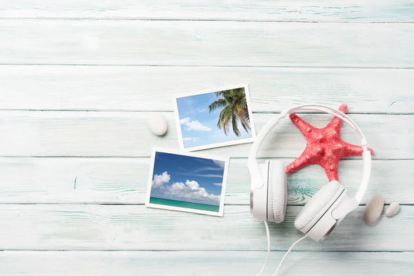 Travel vacation and music concept with headphones, starfish and photos on wooden backdrop. Top view with copy space. Flat lay. All photos taken by me