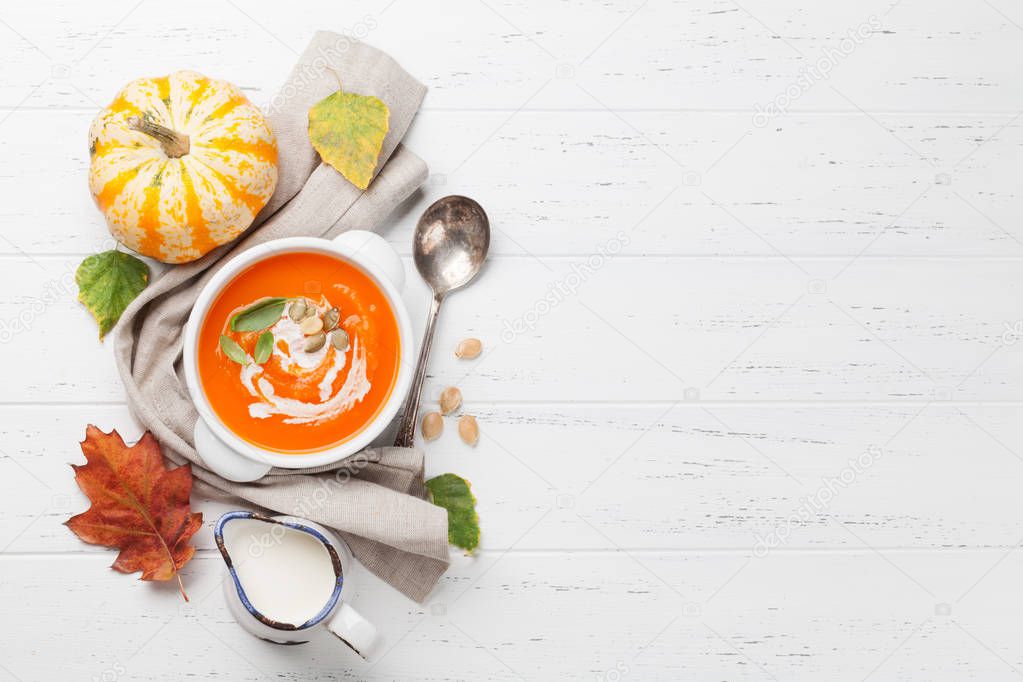 Autumn vegetarian pumpkin cream soup on wooden table. Top view with copy space
