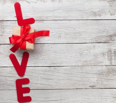 Sevgililer günü tebrik kartı aşk word ve hediye kutusu ahşap arka plan üzerinde. Selam ile alan