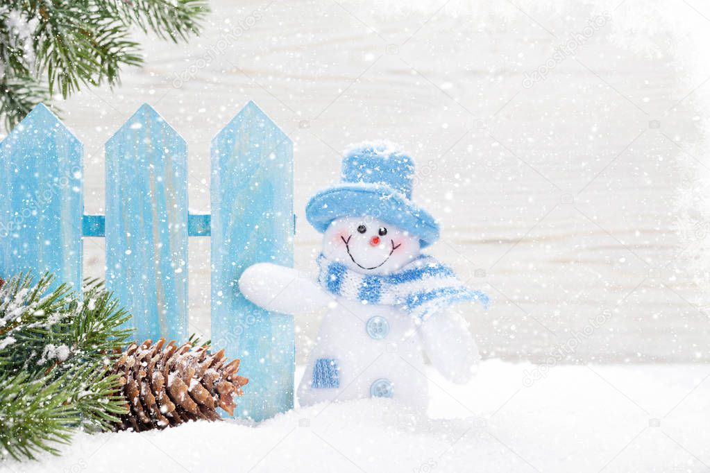 Christmas snowman toy, decor and fir tree branch. Xmas greeting card with space for your greetings