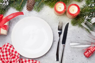 Taş zemin üzerine kar tarafından Noel tablo ayarını mumlar, şampanya, hediye kutusu ve köknar ağacı dalı ile kaplı. Selam yeri olan üstten görünüm