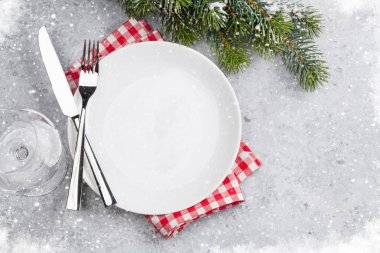 Taş zemin üzerine kar tarafından Noel tablo ayarını köknar ağacı dalı ile kaplı. Boş tabak, çatal ve bıçak. Selam yeri olan üstten görünüm