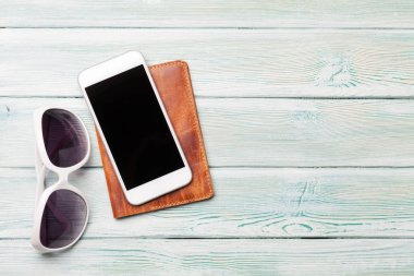 Güneş gözlüğü, smartphone ve ahşap zemin pasaportla seyahat tatil arka plan kavramı. Üstten görünüm kopya alanı ile. Düz yatıyordu