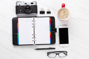 Ofis İşyeri masası Not defteri, sarf malzemeleri, fotoğraf makinesi ve kahve ile. Metin alanı olan üstten görünüm