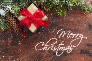 Noel hediye kutusu ve köknar ahşap arka plan üzerinde kar kapsamında şube ağaç. Üstten görünüm xmas zemin alan selam ile