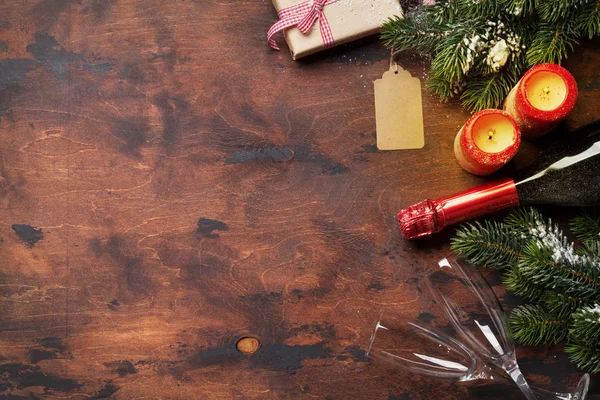 Weihnachtsgeschenkboxen Kerzen Champagner Und Tannenzweige Bedeckt Von Schnee Auf Holzgrund — Stockfoto