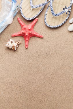 Tatil arka plan kavramı ile parmak arası terlik ve denizyıldızı kum zemin üzerinde seyahat. Üstten görünüm kopya alanı ile. Düz yatıyordu