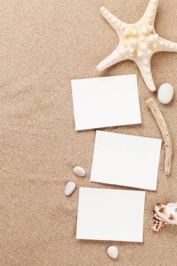 Tatil arka plan kavramı kabukları ve fotoğraf çerçeveleri ile kum zemin üzerinde seyahat. Üstten görünüm kopya alanı ile. Düz yatıyordu