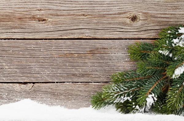 木製の壁の前に雪で覆われてモミの木の枝でクリスマス背景 あなたの挨拶のためのスペースとクリスマス背景 — ストック写真