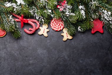 Noel kartı ile gingerbread çerezleri, tatlılar ve taş zemin üzerine kar/EC köknar ağacı dalı. Selam yeri olan üstten görünüm