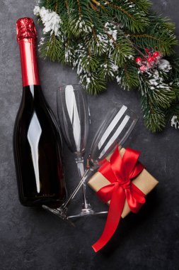 Noel kartı ile şampanya, xmas hediye kutusu ve köknar ağacı taş zemin üzerine kar kapsamında şube. Üstten görünüm