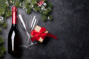 Noel kartı ile şampanya, xmas hediye kutusu ve köknar ağacı taş zemin üzerine kar kapsamında şube. Üstten görünüm zemin ile selam alan. Düz yatıyordu