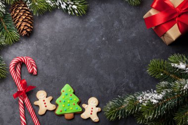 Noel kartı gingerbread çerezleri ve taş zemin üzerine kar/EC köknar ağacı dalı. Selam yeri olan üstten görünüm