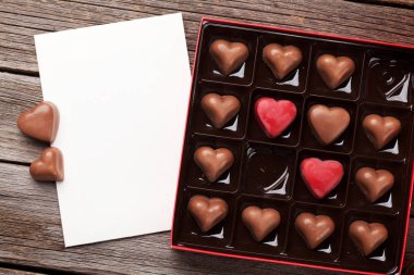 Sevgililer günü tebrik kartı çikolata kutusu ahşap masa üzerinde kalp ile. Selam yeri olan üstten görünüm