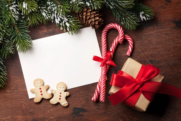 ジンジャーブレッドのクッキー お菓子 ギフト用の箱 モミ付きのクリスマス カードはツリー ブランチの木製の背景に雪で覆われています あなたの挨拶のためのスペースのトップ ビュー — ストック写真