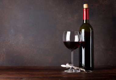 Kırmızı şarap şişe ve cam önünde tahta duvar. Metniniz için kopya alanı ile