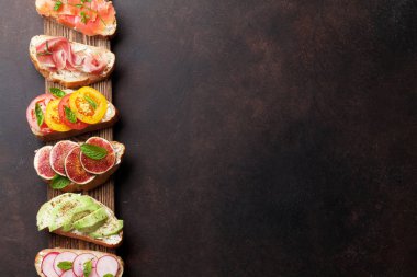 Brushetta veya geleneksel İspanyolca tapas. Meze İtalyan antipasti aperatifler ahşap tahta üzerinde ayarlayın. Üstten görünüm ve düz metin için yer ile göklere