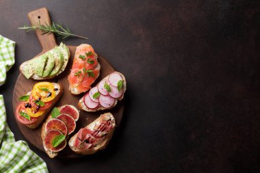 Brushetta veya geleneksel İspanyolca tapas. Meze İtalyan antipasti aperatifler ahşap tahta üzerinde ayarlayın. Üstten görünüm ve düz metin için yer ile göklere