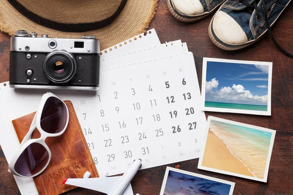 Travel vacation background concept with calendar, sun hat, camera, passport, airplane toy and weekend photos on wooden backdrop. Top view. Flat lay. All photos taken by me