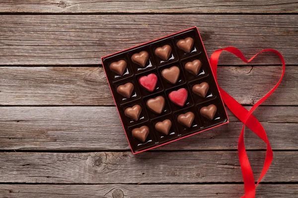 情人节贺卡与心巧克力在盒子在木桌上 为您的问候语提供空间的顶视图 — 图库照片